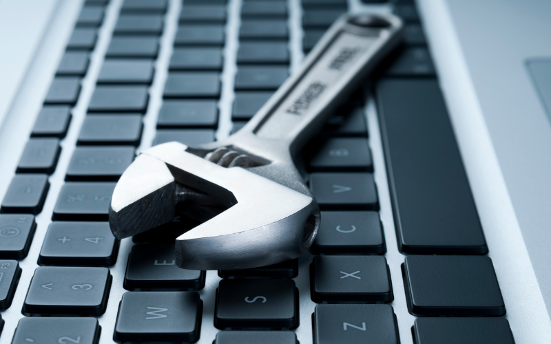 Auf einer Computertastatur liegt ein Werkzeug.